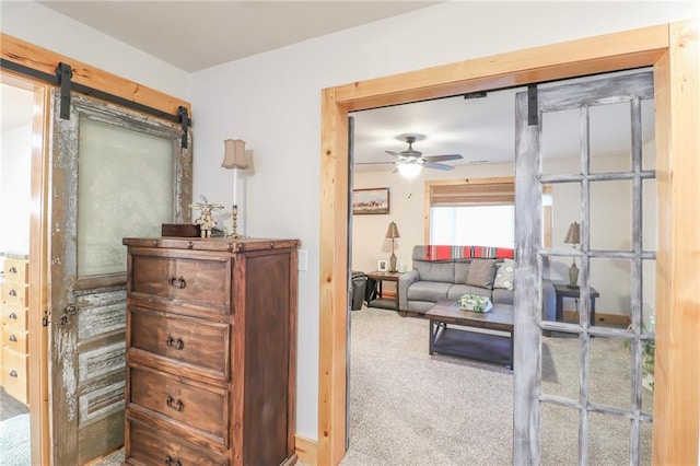 interior space with ceiling fan and a barn door