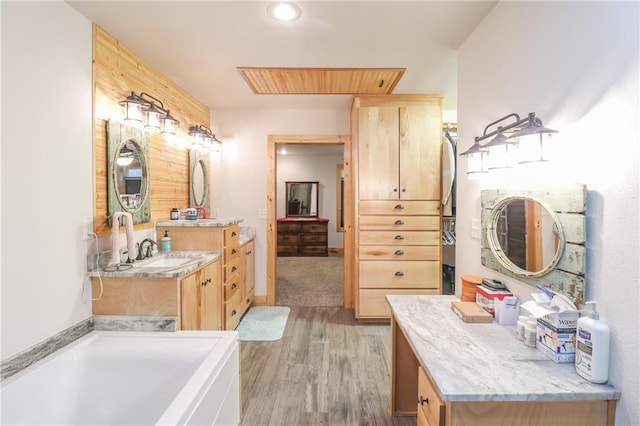 bathroom with hardwood / wood-style floors, vanity, and a bath