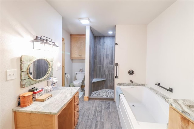 full bathroom with vanity, wood-type flooring, shower with separate bathtub, and toilet