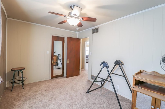 misc room with ceiling fan, light colored carpet, and ornamental molding