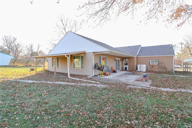 back of house with a lawn and a patio area