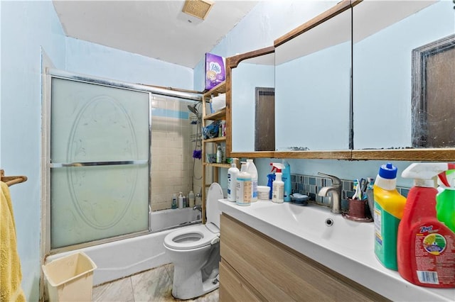 full bathroom featuring toilet, bath / shower combo with glass door, and vanity