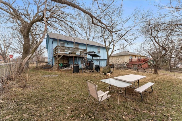 rear view of house featuring stairway, fence, a lawn, and a wooden deck