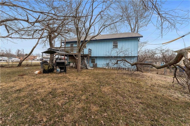 back of property with a yard and fence