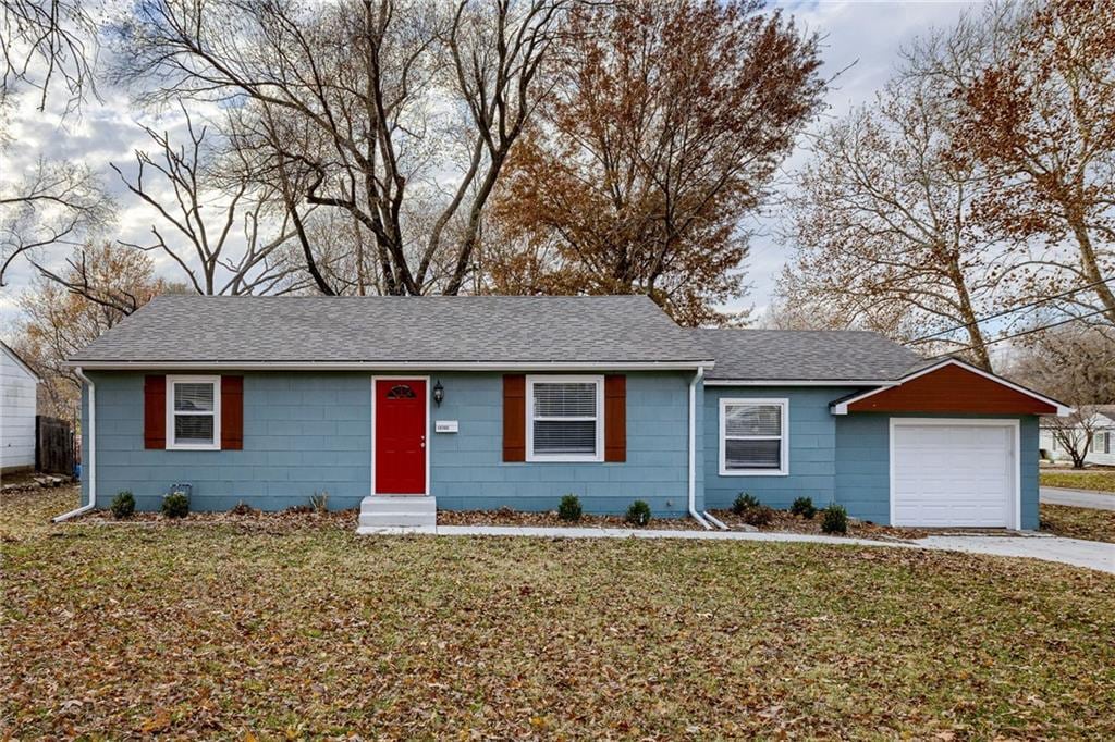 single story home featuring a garage and a front lawn