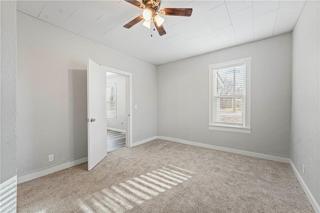 empty room featuring ceiling fan and light colored carpet