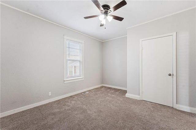 carpeted spare room featuring ceiling fan and ornamental molding