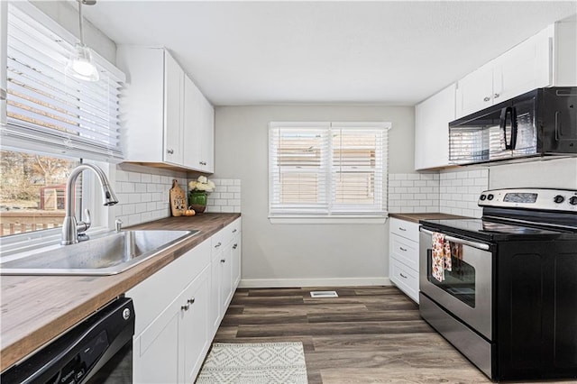 kitchen featuring dark wood-type flooring, black appliances, sink, butcher block countertops, and white cabinetry