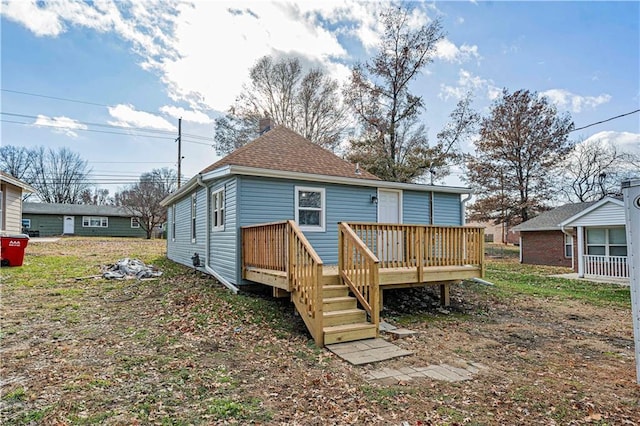 rear view of property featuring a wooden deck