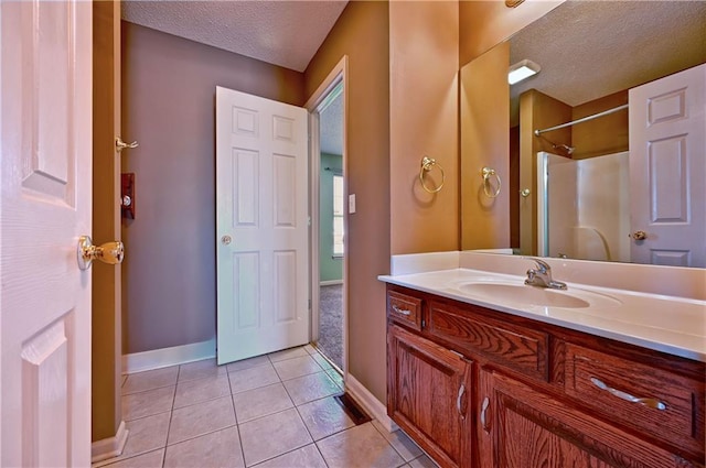 bathroom with a textured ceiling, tile patterned floors, and vanity