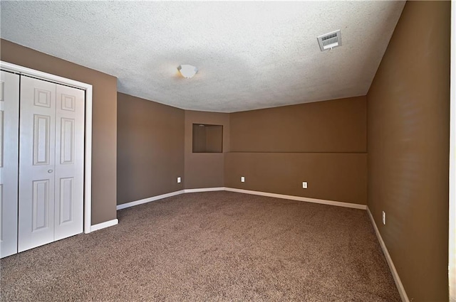 unfurnished bedroom with a textured ceiling, a closet, and carpet