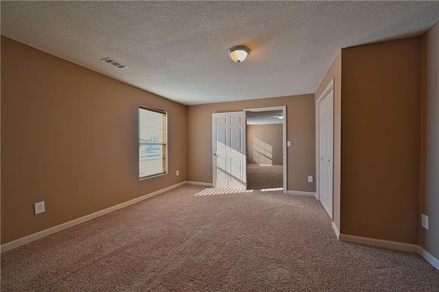 interior space featuring light carpet and a textured ceiling