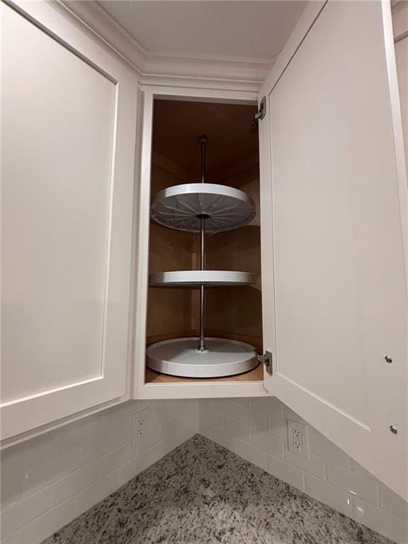 room details featuring white cabinets and light stone countertops