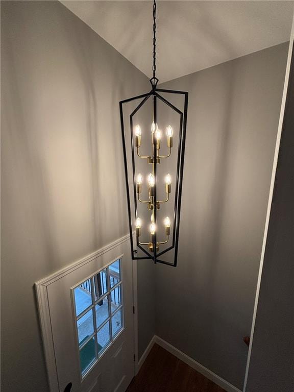 details with baseboards, a notable chandelier, and wood finished floors