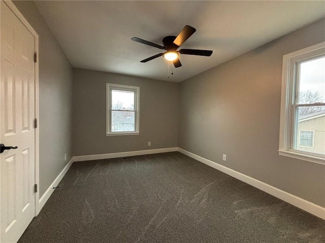 unfurnished room featuring ceiling fan, baseboards, and dark colored carpet