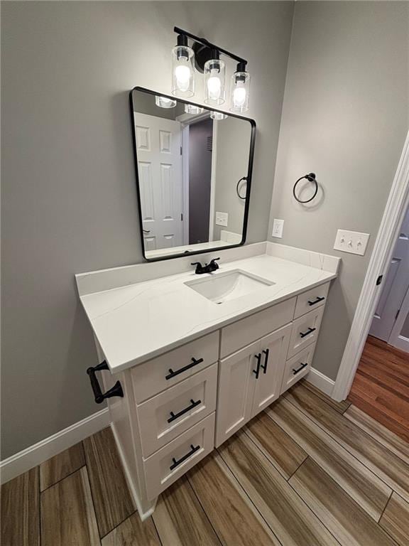 bathroom featuring baseboards, vanity, and wood tiled floor