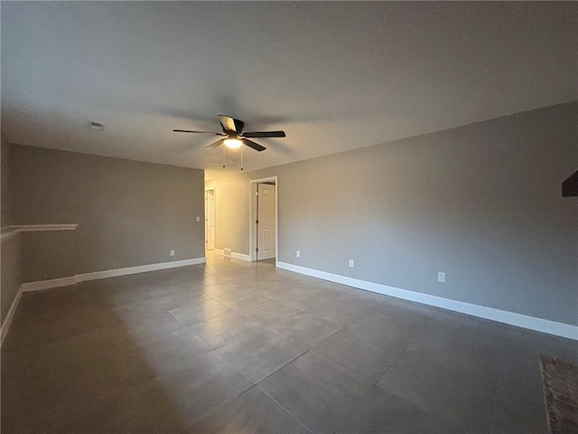 unfurnished room featuring a ceiling fan and baseboards