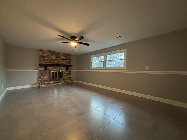 unfurnished living room with a brick fireplace, visible vents, ceiling fan, and baseboards