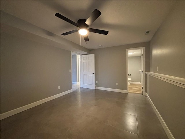 unfurnished bedroom featuring ensuite bath, visible vents, baseboards, and ceiling fan