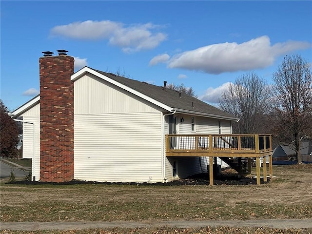 back of property with a chimney and a wooden deck