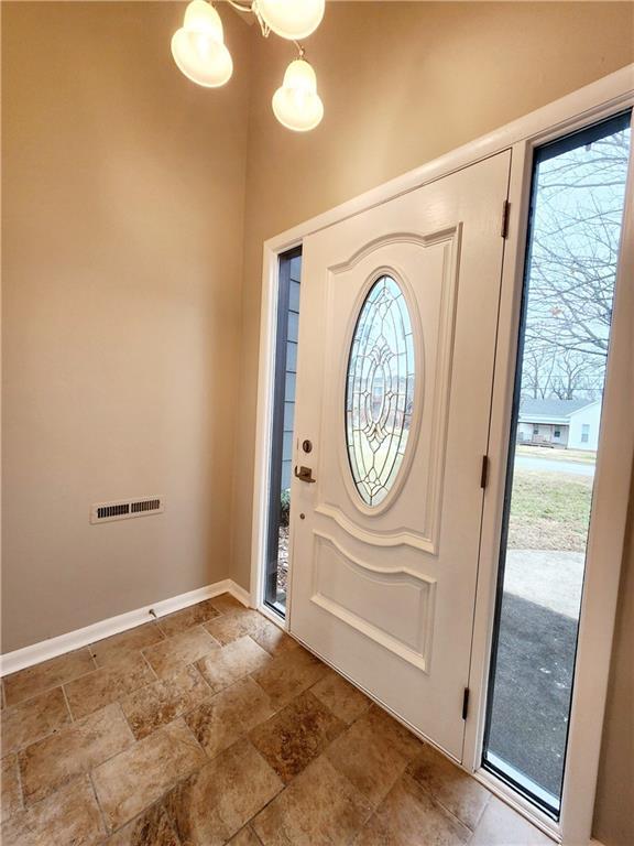 foyer entrance featuring a wealth of natural light and a notable chandelier