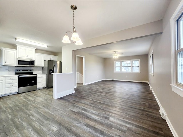 kitchen featuring ceiling fan with notable chandelier, tasteful backsplash, white cabinetry, wood-type flooring, and stainless steel appliances