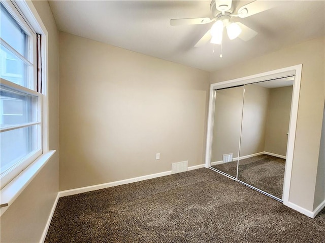 unfurnished bedroom with ceiling fan, a closet, and carpet floors