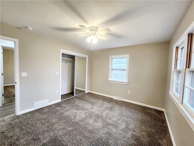 unfurnished bedroom featuring carpet, ceiling fan, a textured ceiling, and a closet