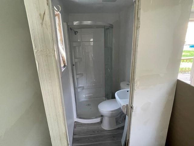 bathroom featuring hardwood / wood-style flooring, toilet, and an enclosed shower