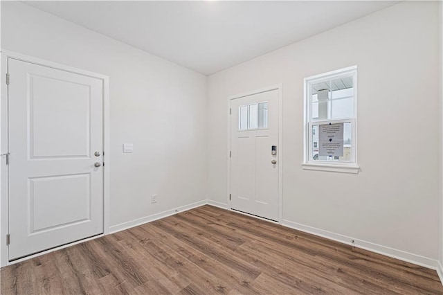 foyer entrance with wood finished floors and baseboards