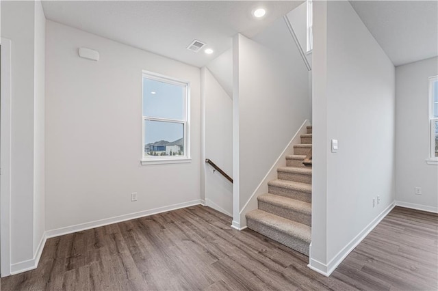 staircase featuring recessed lighting, wood finished floors, and baseboards