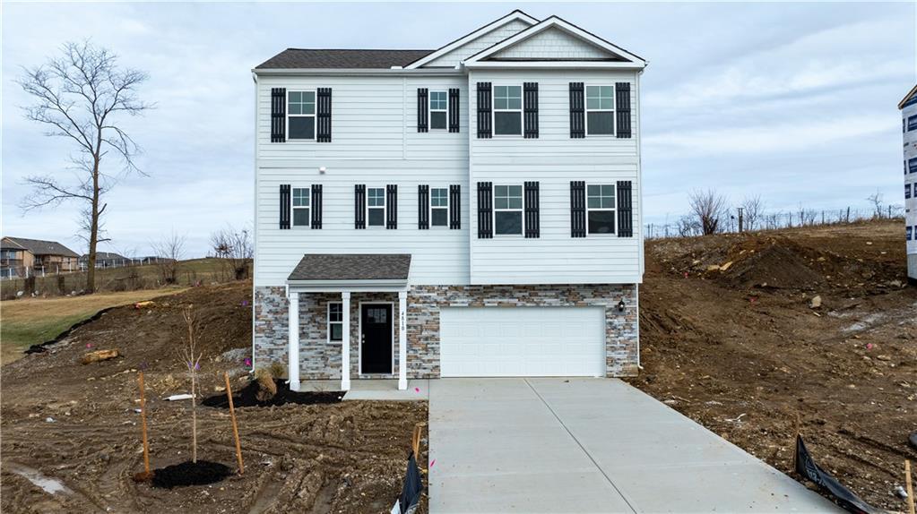 view of front of property featuring a garage, stone siding, and concrete driveway