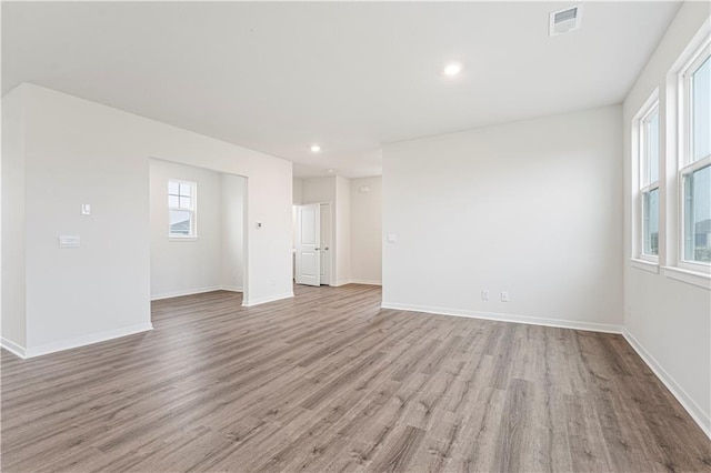 spare room featuring light wood-style flooring, recessed lighting, visible vents, and baseboards