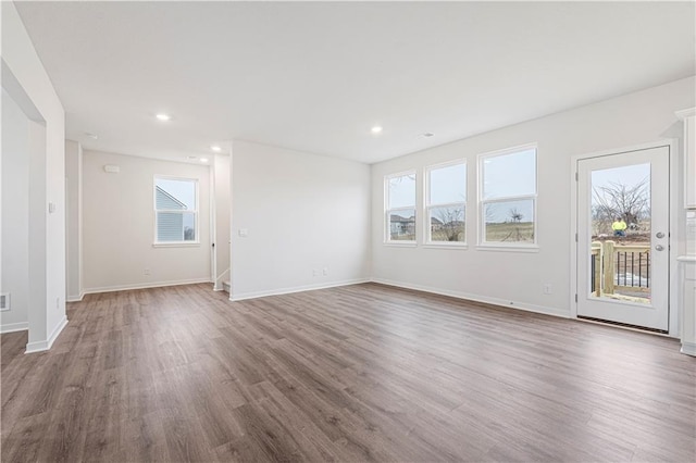 unfurnished living room featuring recessed lighting, baseboards, and wood finished floors