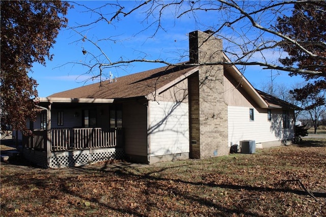 view of side of property with covered porch and central AC