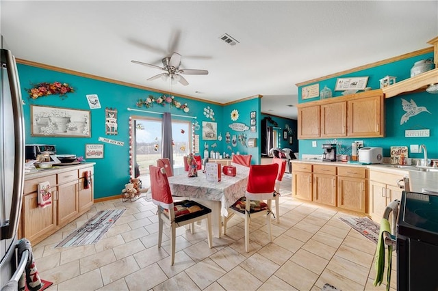 kitchen with light brown cabinets, crown molding, sink, ceiling fan, and range