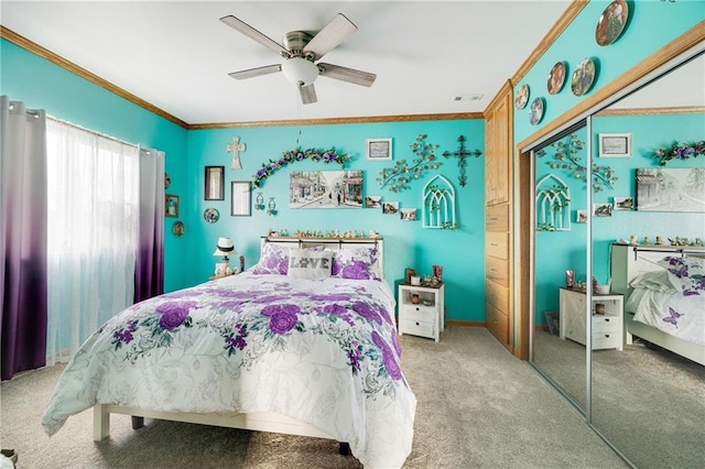 bedroom with ceiling fan, a closet, carpet, and crown molding