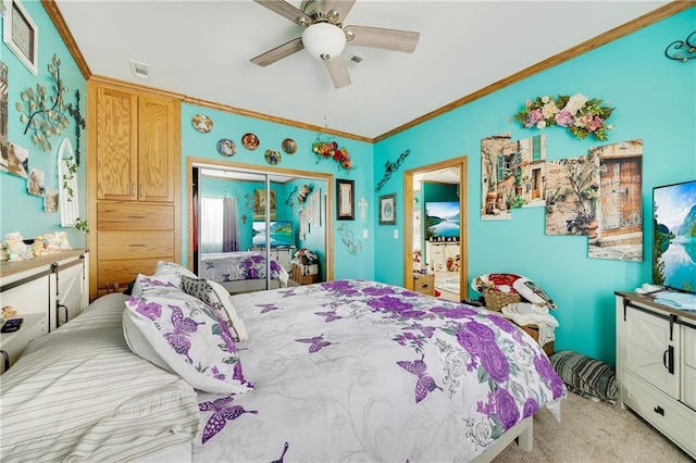 bedroom featuring ceiling fan, ornamental molding, light carpet, and a closet