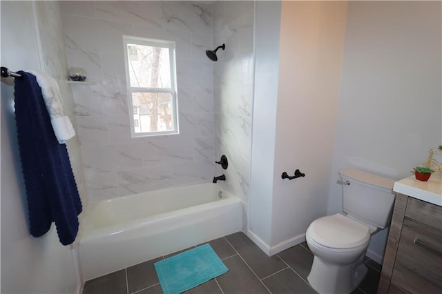 full bathroom featuring tile patterned flooring, tiled shower / bath, vanity, and toilet