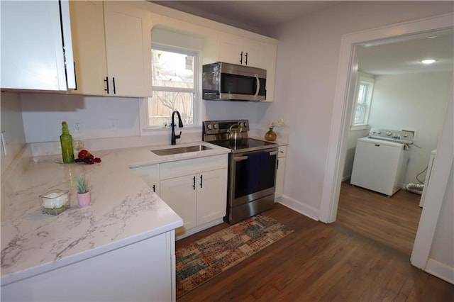 kitchen with dark hardwood / wood-style floors, washer / dryer, sink, white cabinets, and stainless steel appliances