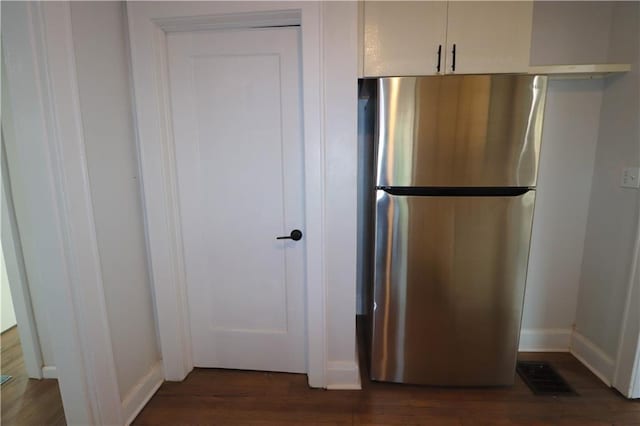 kitchen featuring white cabinetry, dark hardwood / wood-style flooring, and stainless steel refrigerator