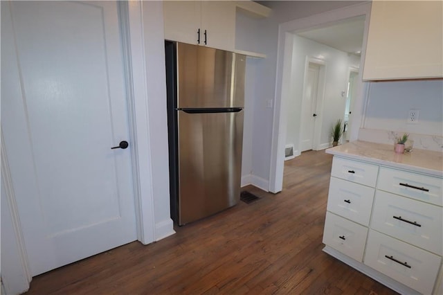 kitchen with white cabinetry, dark hardwood / wood-style floors, and stainless steel fridge