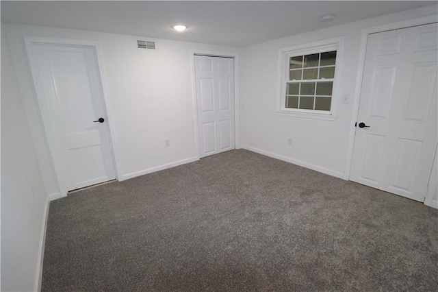 unfurnished bedroom with dark colored carpet