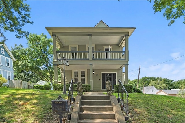 view of front of property featuring covered porch, a balcony, and a front lawn