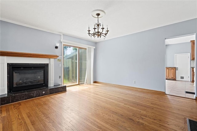 unfurnished living room featuring ornamental molding, a notable chandelier, and light wood-type flooring