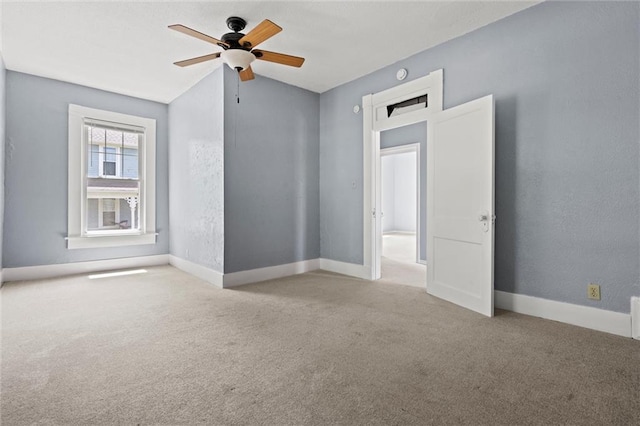 spare room with light carpet, vaulted ceiling, and ceiling fan