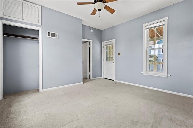 unfurnished bedroom with ceiling fan, light colored carpet, and a closet