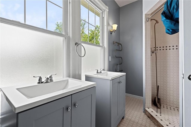 bathroom featuring tile patterned flooring, vanity, and tiled shower