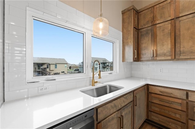 kitchen featuring sink, decorative light fixtures, decorative backsplash, and dishwasher