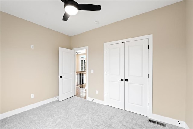 unfurnished bedroom with light carpet, ceiling fan, and a closet